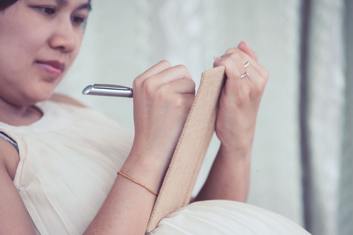 pregnant-woman-writing-notebook-list-necessary-things-prepare-birth-baby.jpg