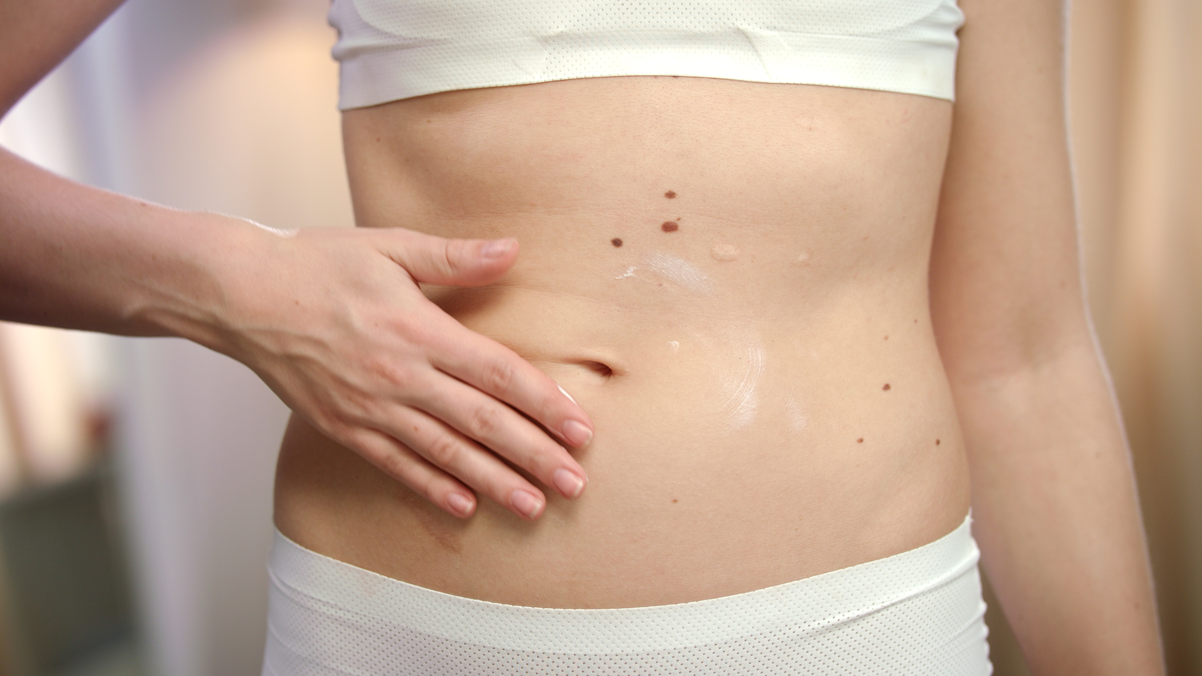 woman-hand-applying-body-cream-abdomen-woman-belly-skincare.jpg